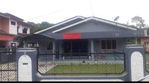 a house with a gate in front of it at D'Aman Guesthouse Pontian in Kampong Parit Tengah