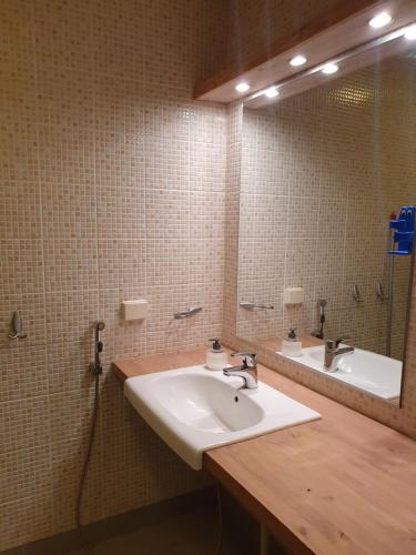 W łazience znajduje się umywalka i lustro. w obiekcie Hostelli Kotiranta w mieście Lieksa