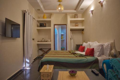 Riad Tama & spa في ورززات: غرفة نوم بسرير واريكة في غرفة