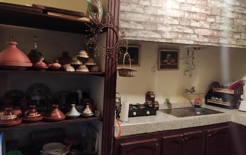 a kitchen with a sink and a counter with pots and pans at Grotte Thami in Bhalil