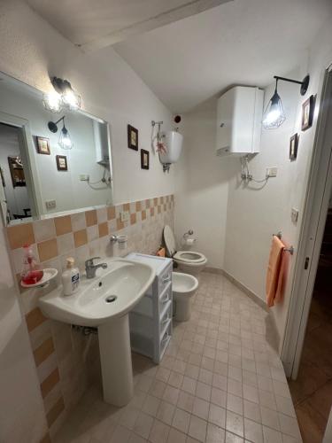 y baño con lavabo, aseo y espejo. en Relax home en San Massimo