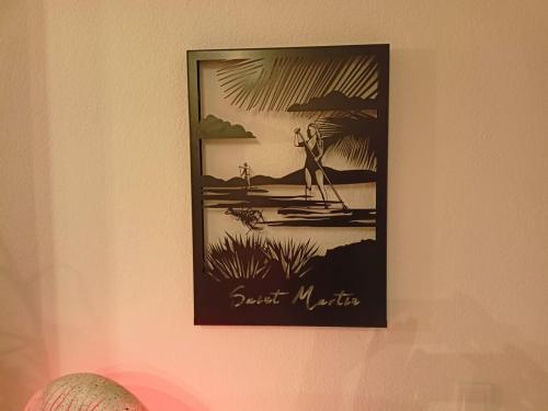 a picture of a man on a beach on a wall at PERLE DES ANTILLES in Oyster Pond