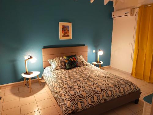 1 dormitorio con cama y pared azul en PERLE DES ANTILLES, en Oyster Pond