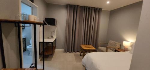 a hotel room with a bed and a table at Chai & Spice Guesthouse and Café in George