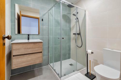 een badkamer met een douche, een wastafel en een toilet bij IN Setubal in Setúbal