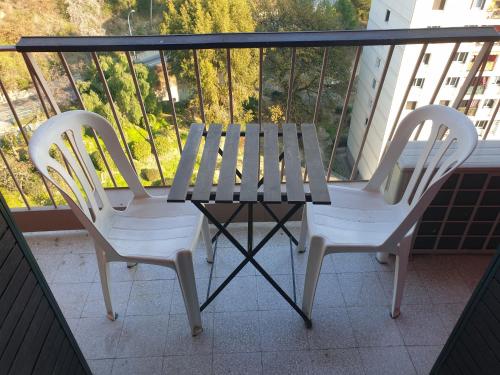 two white chairs and a table on a balcony at NEW CHEAP PRIVATE ROOM, KITCHEN , OVERWIEUW sea,TRAM on spot, 12 minutes from nice train station with tram , beach in 17 min tram , CHAMBRE PRIVÉE pas cher, cuisine équipée , tram sur place, APERÇU mer, 12 min de la gare de Nice avec le tram, 17 min plage in Nice