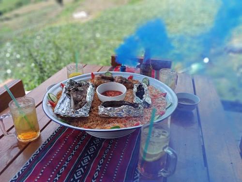 a plate of food sitting on a picnic table at MAK Homstay Room in Kundasang