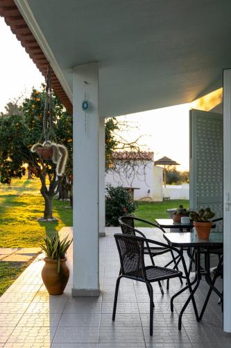a patio with a table and chairs on a porch at Na Quinta- alojamento rural com piscina de água salgada in Poceirão