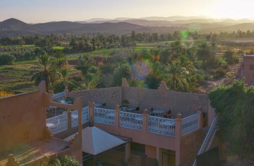an aerial view of a house with a balcony and palm trees at Riad Tama & spa in Ouarzazate