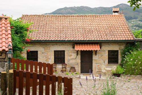 una casa de piedra con una valla delante de ella en Casa das Infusões - Soalheiro, en Melgaço