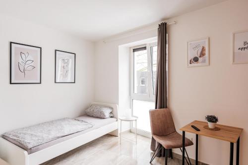 1 dormitorio con cama, escritorio y ventana en Apartments Cologne, en Colonia