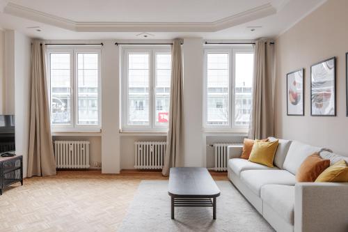 uma sala de estar com um sofá branco e janelas em Flats 4 You, Moderne City Wohnung Nähe HBF, DÜ-Messe 20 Min, Netflix, Küche em Duisburg