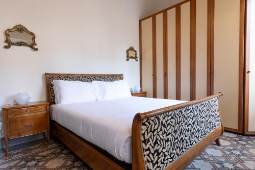 sypialnia z łóżkiem z drewnianym zagłówkiem w obiekcie Fossi Elegant Apartment we Florencji