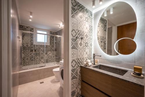 een badkamer met een wastafel, een toilet en een spiegel bij Sofias LemonTree Family House in Agios Nikolaos