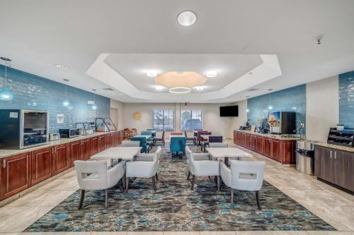 a restaurant with tables and chairs in a cafeteria at La Quinta by Wyndham PCB Pier Park area in Panama City Beach