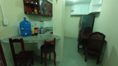 cocina con mesa, sillas y nevera en Avispero's House, en Baños