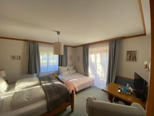 een hotelkamer met 2 bedden en een bureau bij Pension Rangger in Radfeld