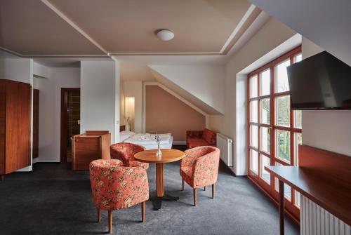 a room with a table and chairs and a bed at Penzion Velký mlýn in Hlučín