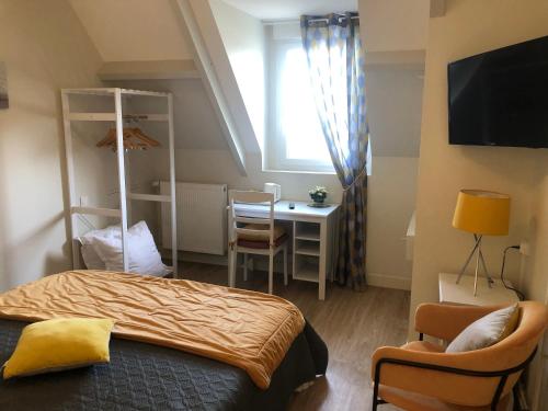 a bedroom with a bed and a desk and a window at La Villa Port Winston - Face Mer B&B in Saint-Côme-de-Fresné