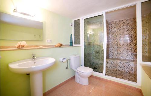 La salle de bains est pourvue d'un lavabo, de toilettes et d'une douche. dans l'établissement Awesome Home In Moraira With Private Swimming Pool, Can Be Inside Or Outside, à Teulada