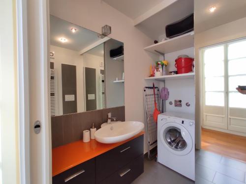 a bathroom with a sink and a washing machine at Solferino Apartment 2 in Turin
