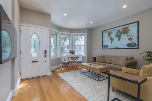 a living room with a couch and a table at Sunny convenient home w/ private patio! Easy walk to everything! in Boston