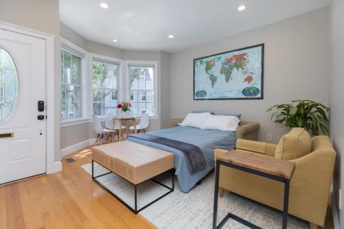 a bedroom with a bed and a table at Sunny convenient home w/ private patio! Easy walk to everything! in Boston