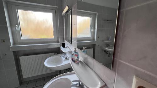 a bathroom with a sink and a toilet and a mirror at Apartmenthaus Somborn in Bochum
