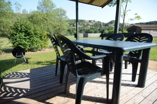 a table and chairs sitting on a deck with a table at Les Chalets de Condrieu in Condrieu