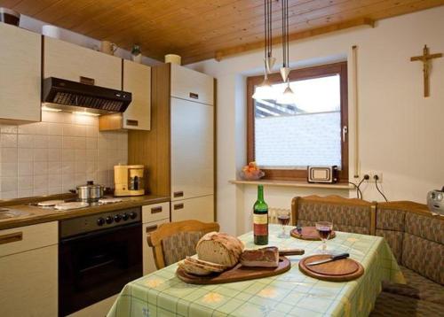 eine Küche mit einem Tisch und einer Flasche Wein in der Unterkunft Ferienwohnung Talblick in Titisee-Neustadt