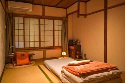 a room with a bed in a room with a window at Toyooka guesthouse Hostel Act in Toyooka