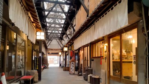 an empty hallway in a building with many windows at Toyooka guesthouse Hostel Act in Toyooka