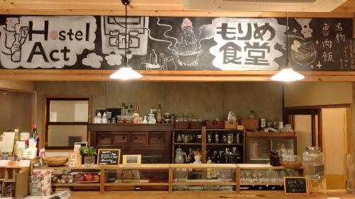 a restaurant with a sign on the wall at Toyooka guesthouse Hostel Act in Toyooka