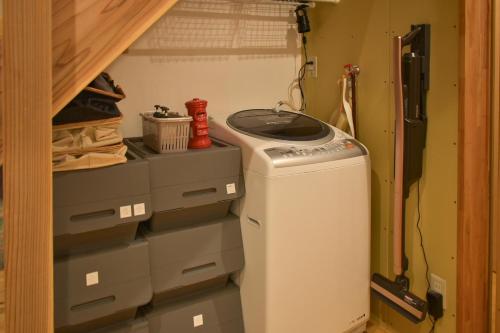 a washer and dryer sitting in a closet at Toyooka guesthouse Hostel Act in Toyooka