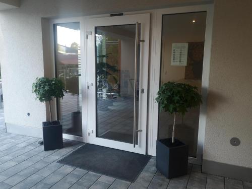two potted plants in front of a glass door at Franzl Hof Zorell in Ravensburg