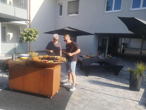 two men standing next to a table with a tray of food at Franzl Hof Zorell in Ravensburg