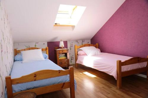 2 bedden in een zolderslaapkamer met paarse muren bij La Rose des Sables maison de pêcheur de 7 pers. in Les Sables-dʼOlonne