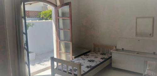 Dormitorio pequeño con cama y espejo en CASA AZUL, en Peruíbe