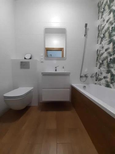 een badkamer met een toilet, een wastafel en een bad bij APARTAMENT UNIEJÓW Długa in Uniejow