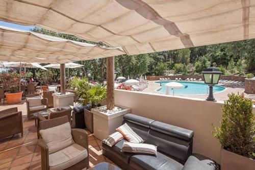 une terrasse meublée et une piscine dans l'établissement Les Restanques Maison 14 Chênes, à Grimaud