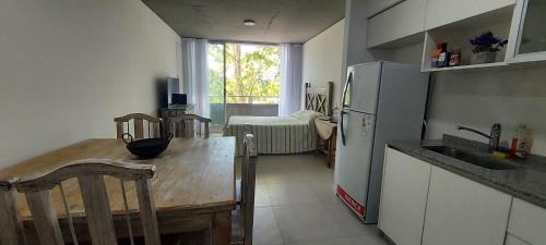 a kitchen with a wooden table and a refrigerator at Espacioso monoambiente en pleno centro in Adrogué