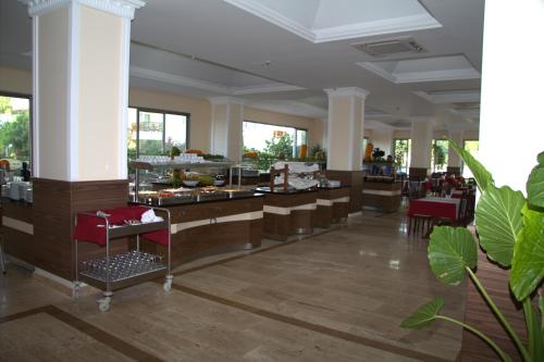 a restaurant with a buffet line with tables and chairs at MIRAMOR HOTEL & Spa - ULTRA ALL INCLUSIVE SELECTION in Kemer