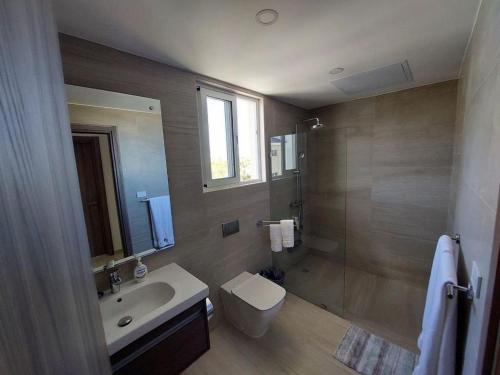 a bathroom with a toilet and a sink and a shower at Cozy 1BDR with Pool Golf View in Hard Rock Golf in Punta Cana