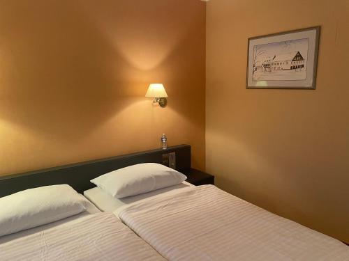 a bedroom with two beds and a picture on the wall at Hotel de la Station in Scheidgen