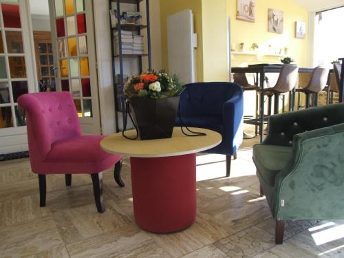 a table with a vase of flowers on top of it at La Villa Port Winston - Face Mer B&B in Saint-Côme-de-Fresné