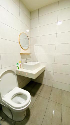 a bathroom with a toilet and a sink and a mirror at The Icon2 Condo in IOI City Mall Putrajaya, Pool View in Putrajaya