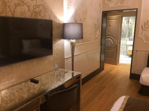 um quarto de hotel com uma televisão de ecrã plano na parede em Santa Croce Boutique Hotel em Veneza