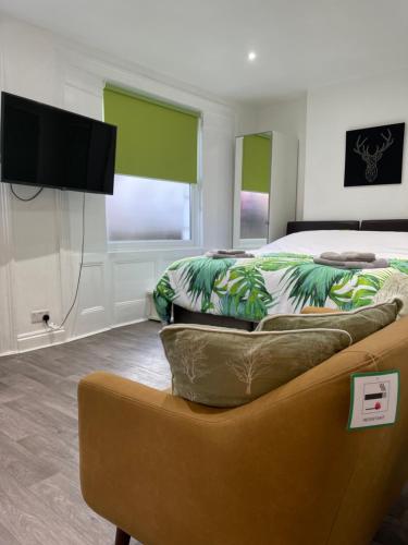a bedroom with a bed and a couch and a tv at Mildmay Road Apartments in London