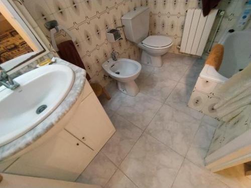 a bathroom with a sink and a toilet and a sink at Villa Service - Prat de Calafell in Calafell