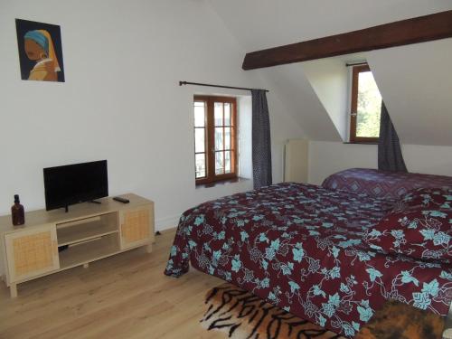 a bedroom with a bed and a flat screen tv at LA VILLA QUI A DU CHIEN in Neuville-sur-Touques